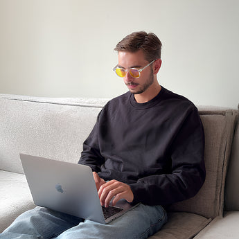 Jongen met Blauwlichtbril Daygold van AmaraPure terwijl hij een laptop gebruikt
